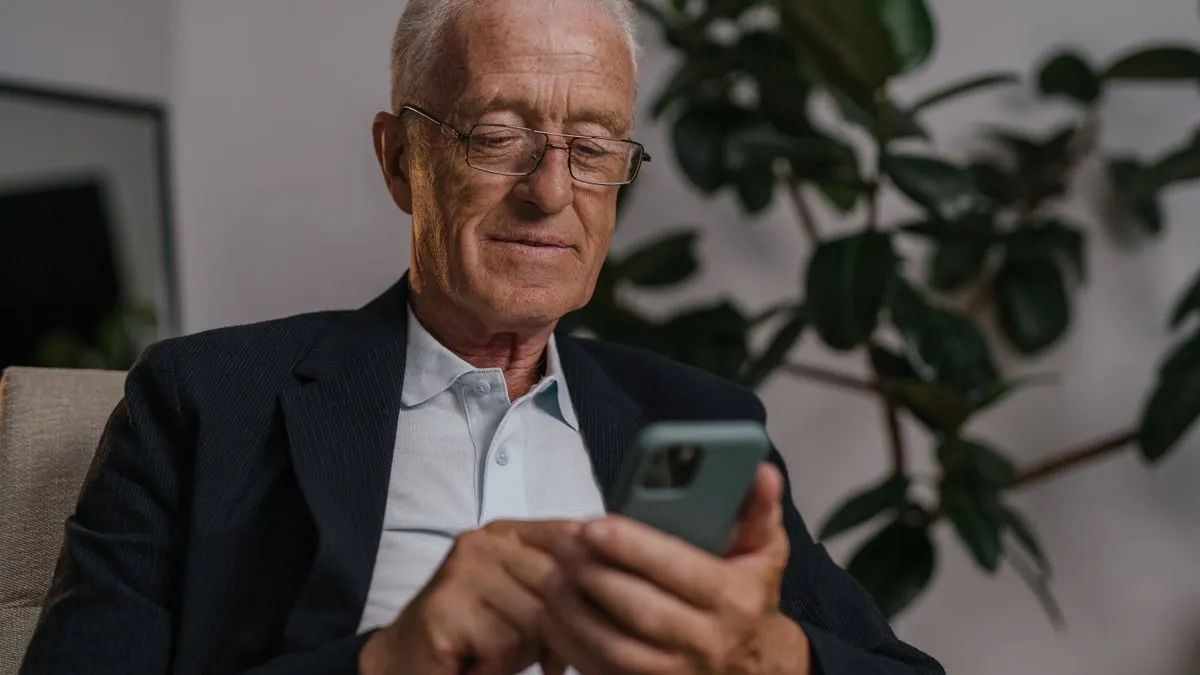 Retired man checking his OAS payment by direct deposit on a phone
