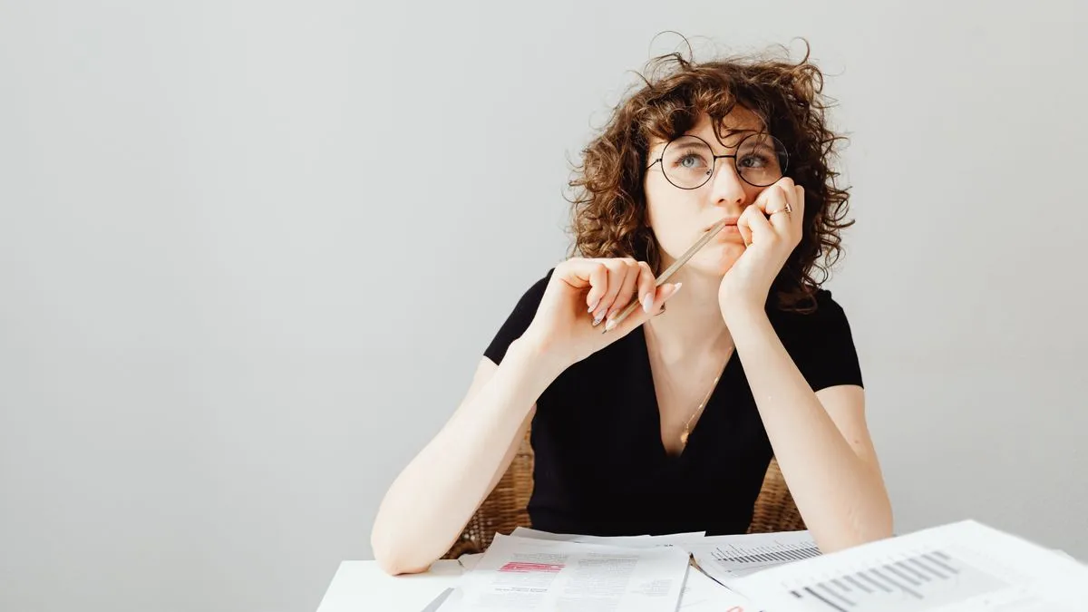 Woman weighing how to borrow money by comparing loan documents