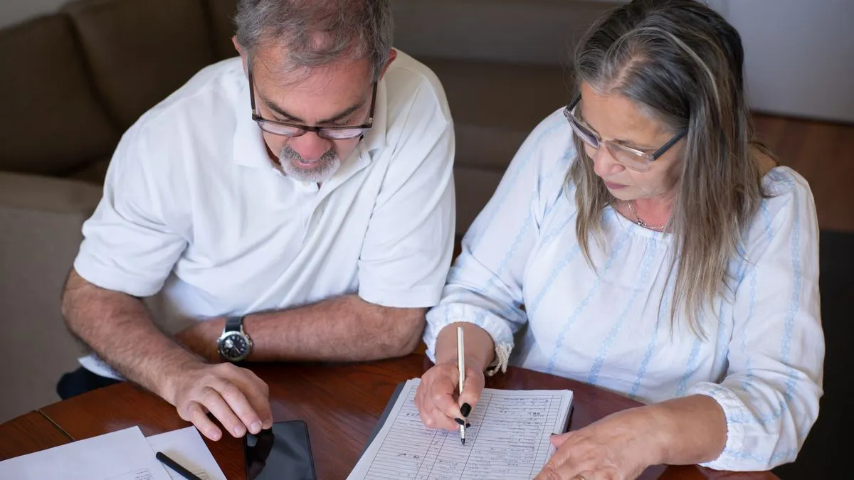 Older couple completing CPP retirement pension paperwork together before the next CPP payment dates
