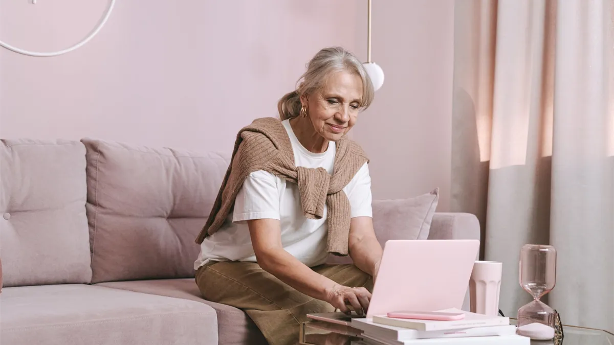 Senior woman checking her Guaranteed Income Supplement amount online with a laptop