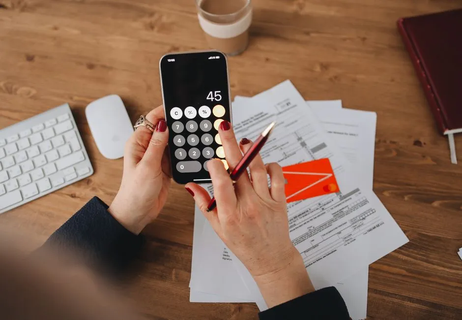 Person using a phone calculator to see how credit scores are calculated in Canada