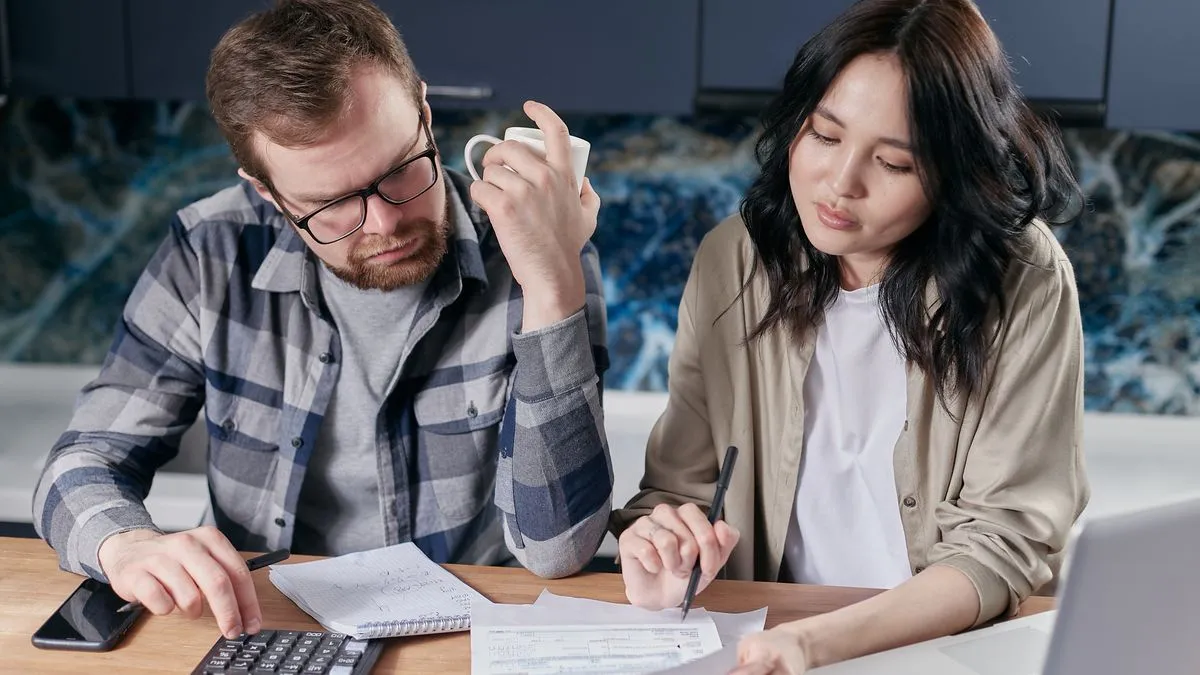 Couple working out how to borrow money in Canada at their kitchen table