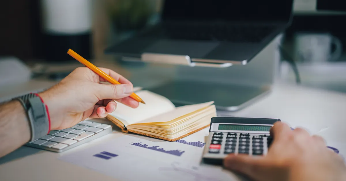 Person comparing ways to borrow money in Canada with a calculator and laptop
