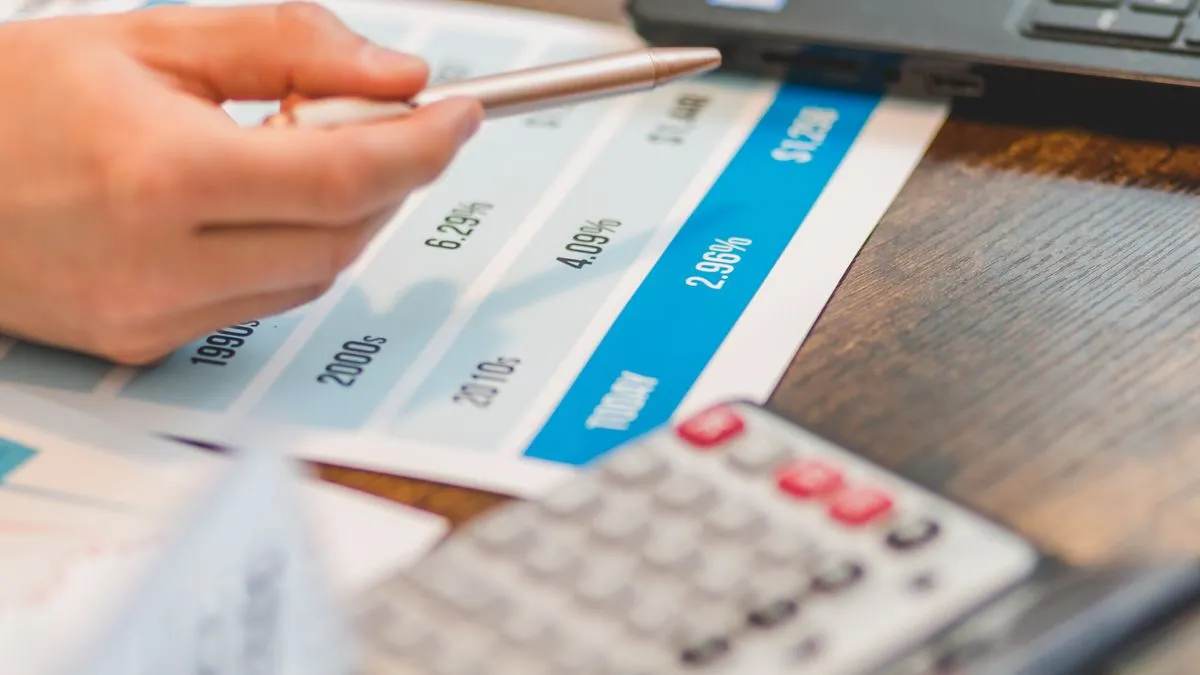 Borrower comparing personal loan interest rates on a chart with a calculator