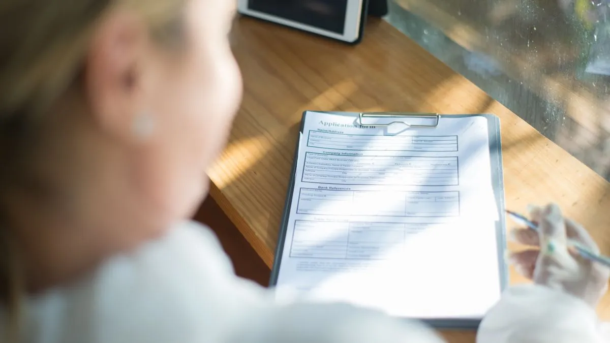 Person filling out an application form like a Social Insurance Number application