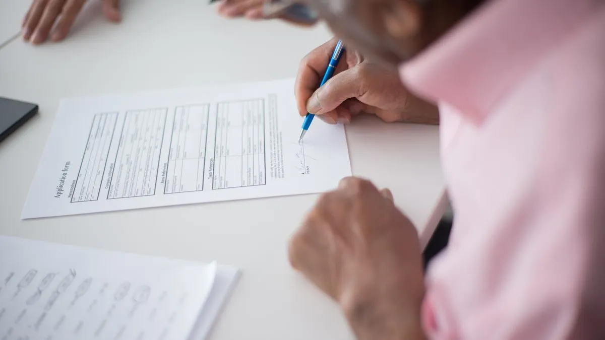 Signing a form to apply for a Social Insurance Number in Canada