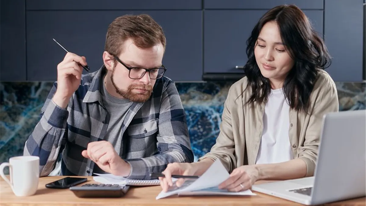 Couple reviewing bills and mapping their monthly Ontario Trillium Benefit payment dates at home