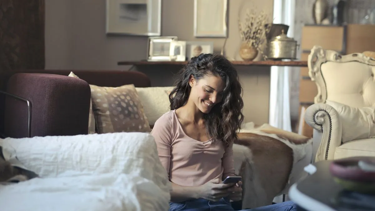 Woman checking a government benefit direct deposit on her phone at home