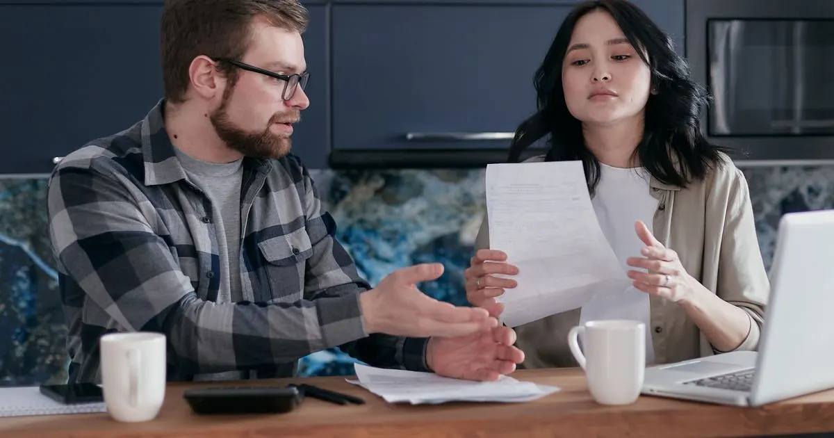 Couple comparing payday loan vs installment loan costs on paper