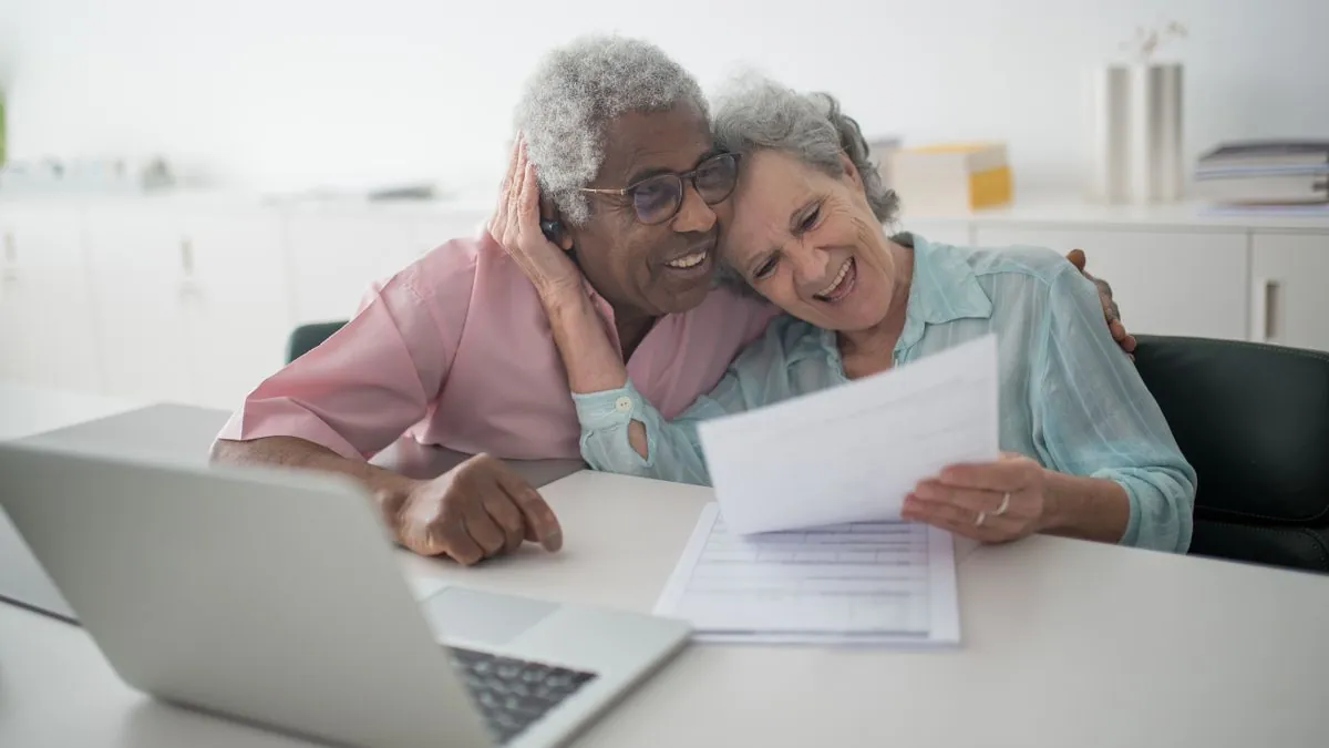 Happy senior couple reviewing their CPP and OAS payment dates at home