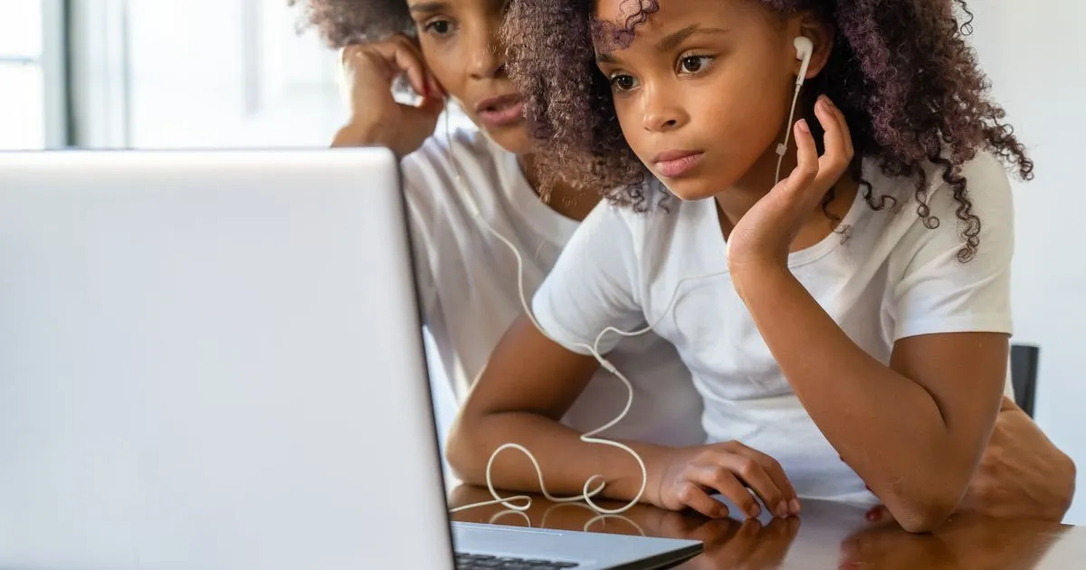 Single parent benefits application done online by a mother and daughter on a laptop