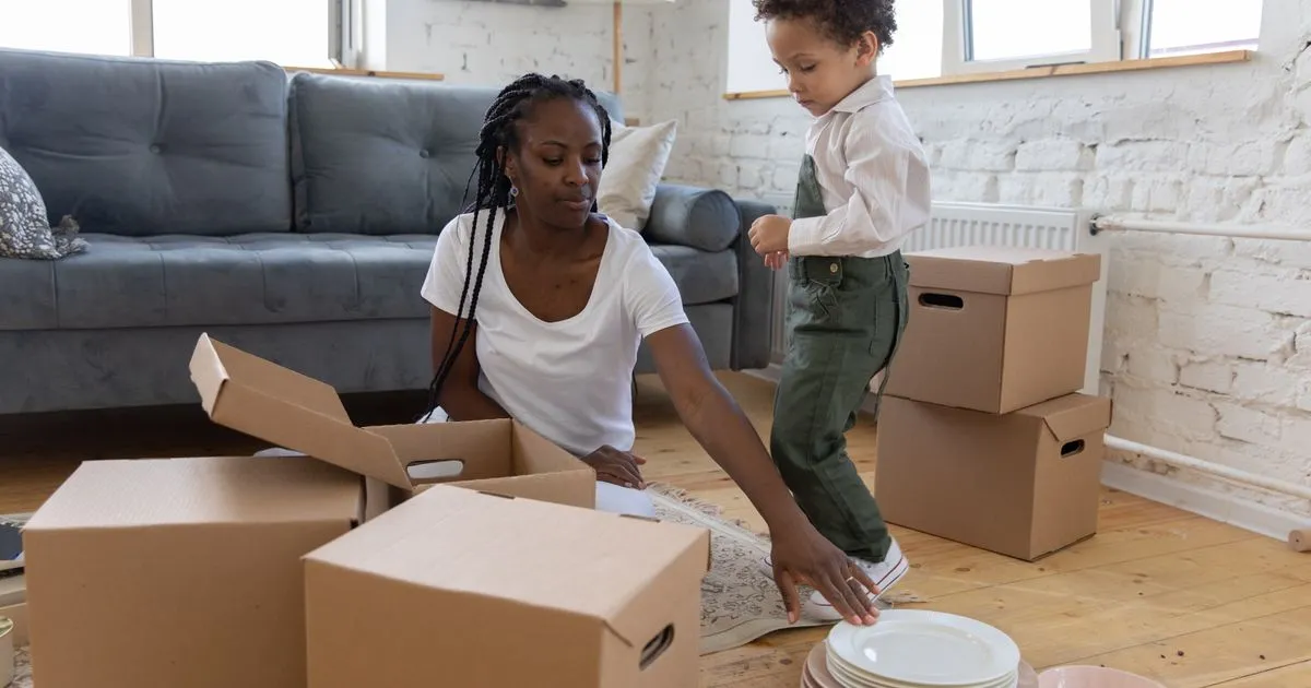 Single mother and son unpacking boxes after finding housing help for single parents