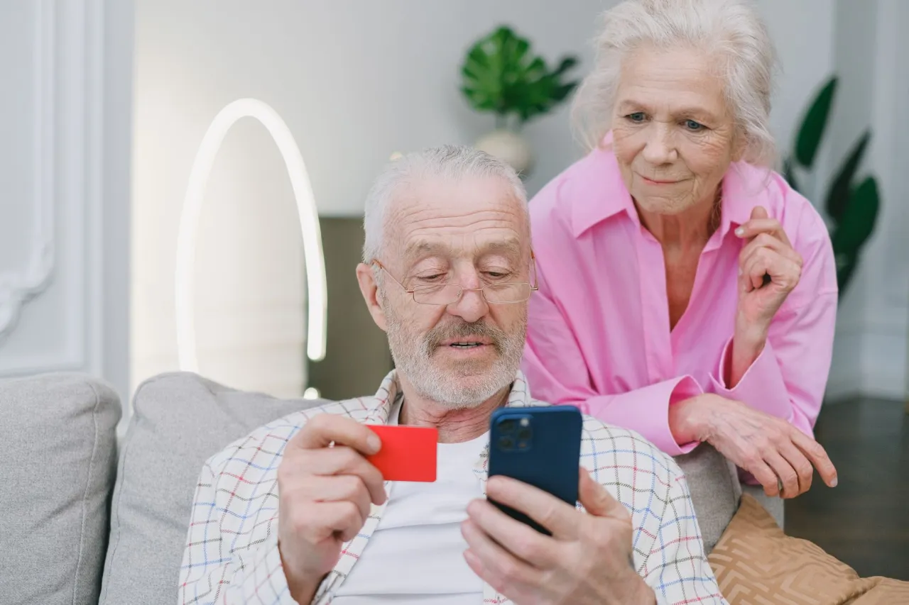 Senior checking a discount offer on his phone before paying