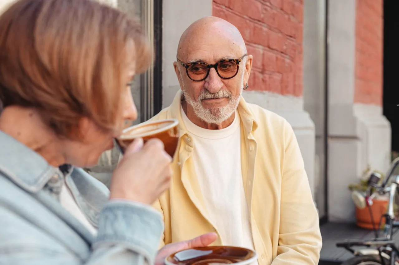 Senior couple enjoying coffee at a cafe where a seniors discount applies
