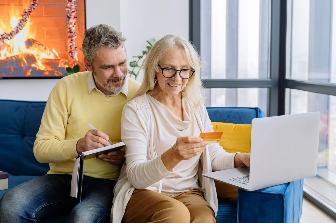 Senior couple hunting seniors discounts online with a laptop at home