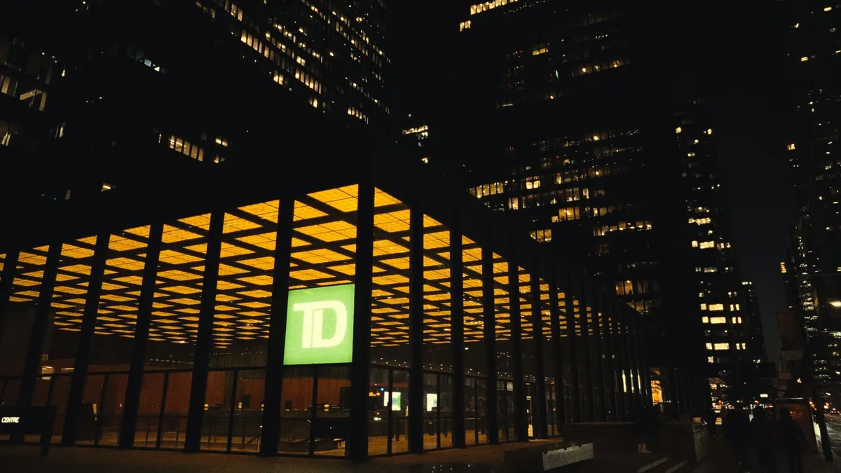TD Centre in downtown Toronto lit up at night; every Canadian bank prints the same cheque layout, so you write a cheque the same way at each